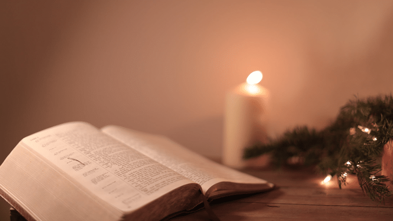 Open Bible with candlelight
