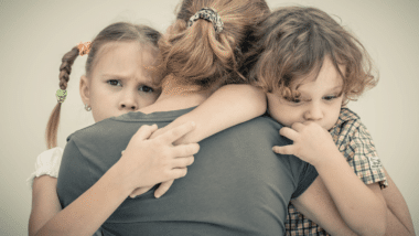 Mother hugging children